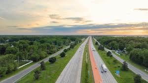A highway stretches into the distance with vehicles driving on it